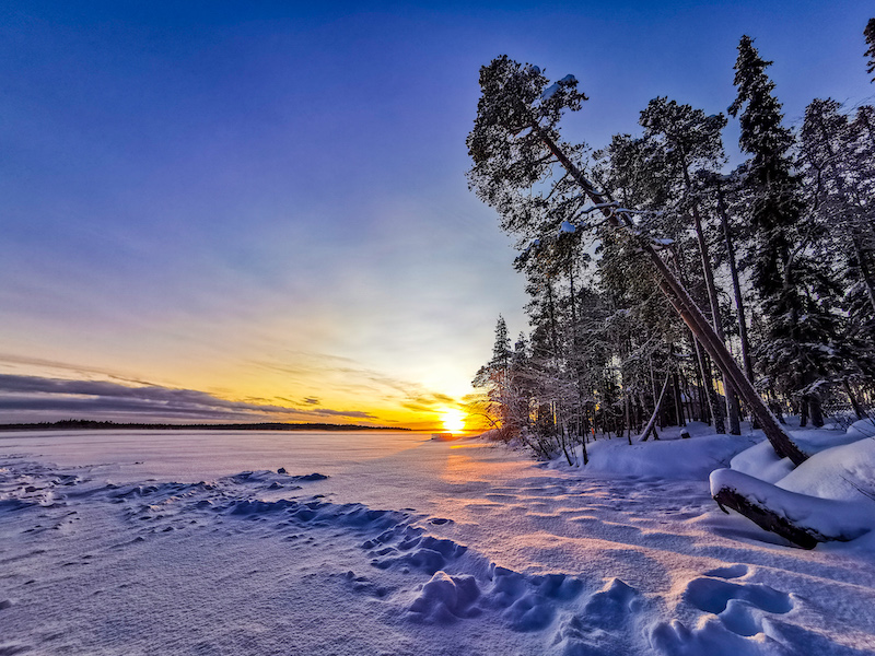A sunrise over a frozen lake in Rovaniemi Lapland