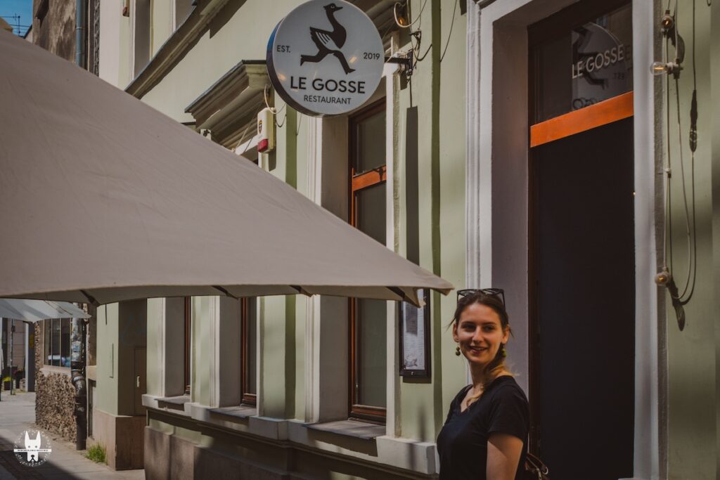 A girl standing in front of Le Gosse restaurant in Wrocław