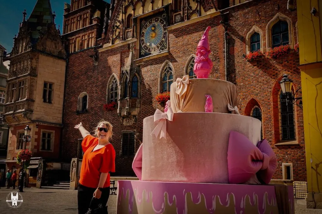 A tourist posing in front of Wrocl1aw Ratusz during Wrocław Dwarf Festival 2024