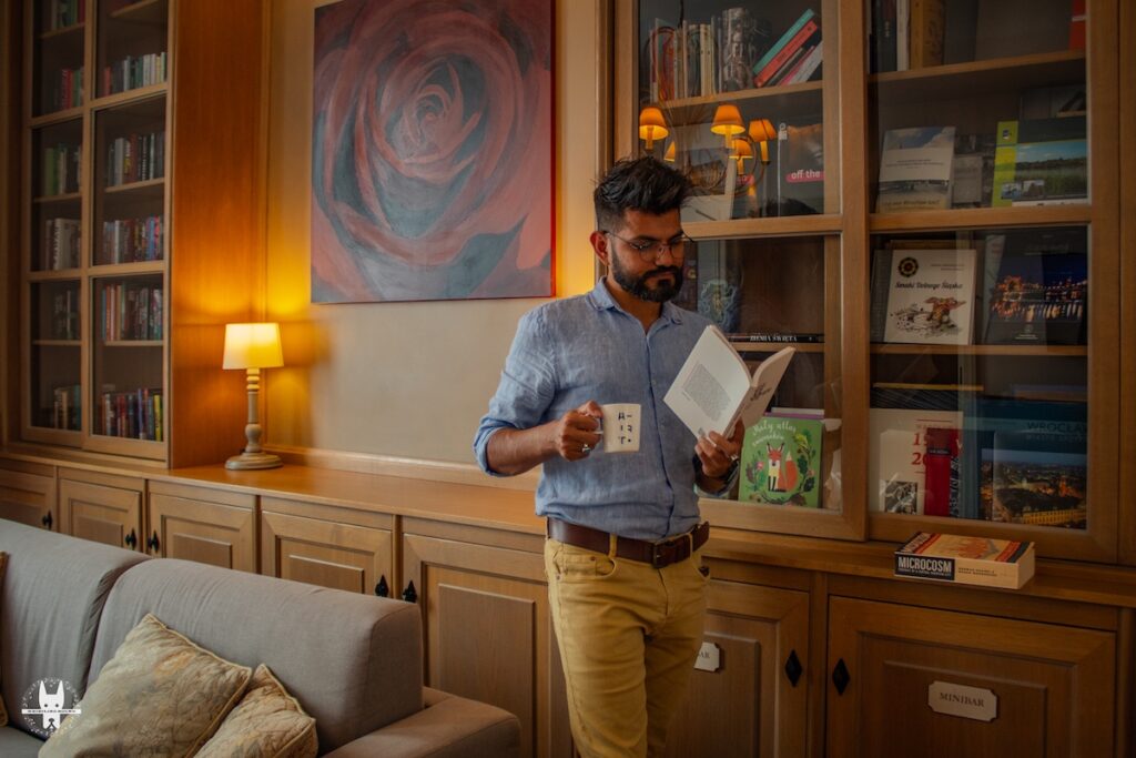 Whistling Hound reading library book in the living room of Art Hotel Wrocław Apartment